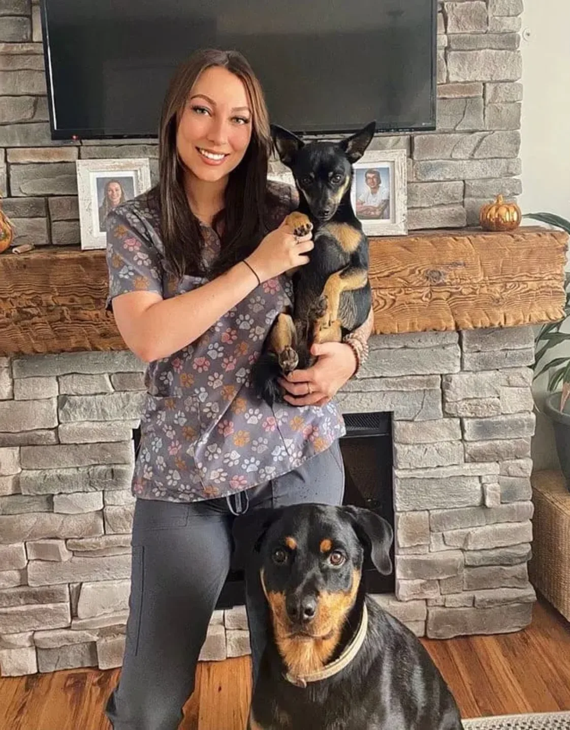 Staff photo of Taylor holding a small black dog and a bigger black dog sitting in front of her. Staff photo of Taylor holding a small black dog and a bigger black dog sitting in front of her.