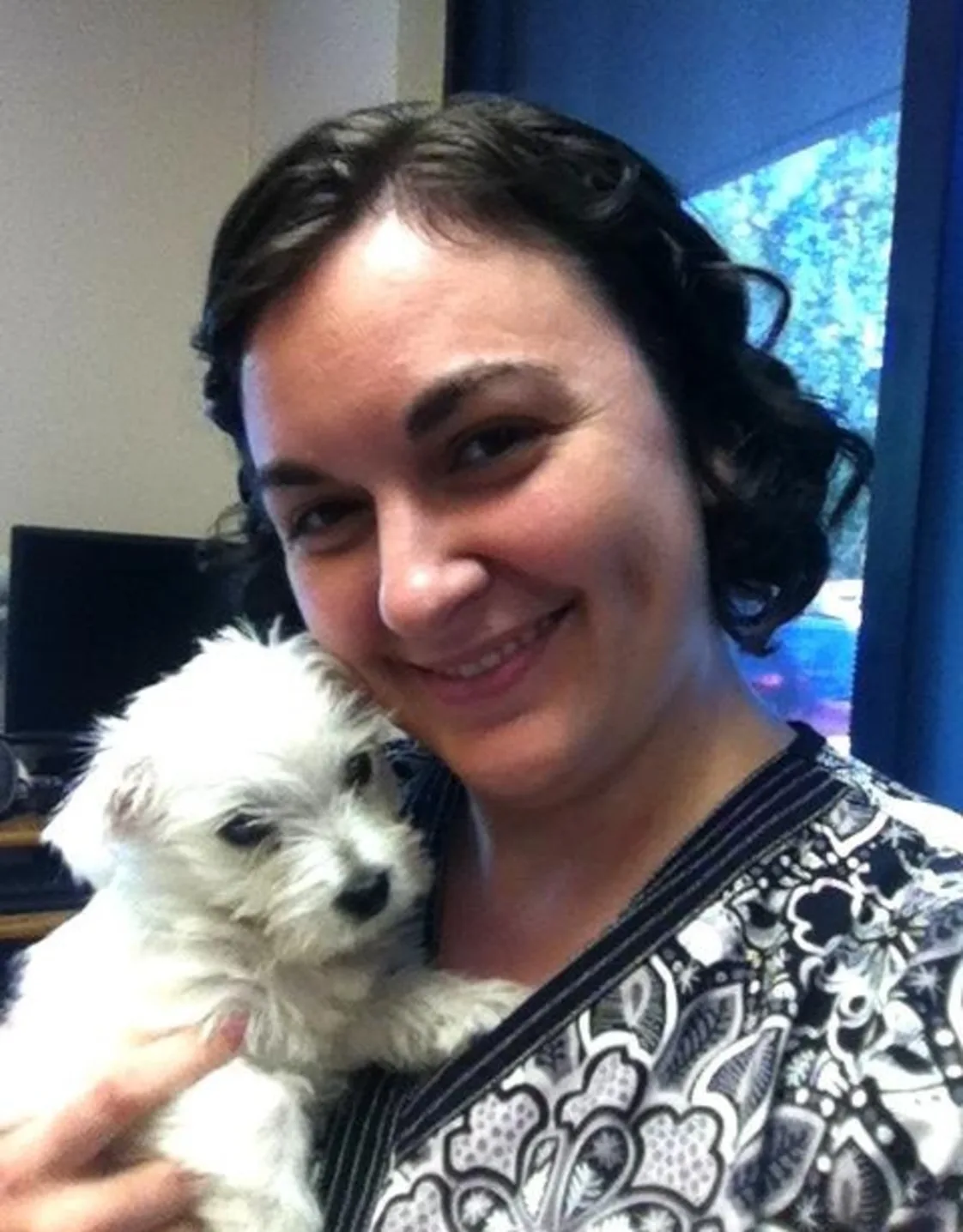 Maggie holding onto a white fluffy puppy. Maggie holding onto a white fluffy puppy.