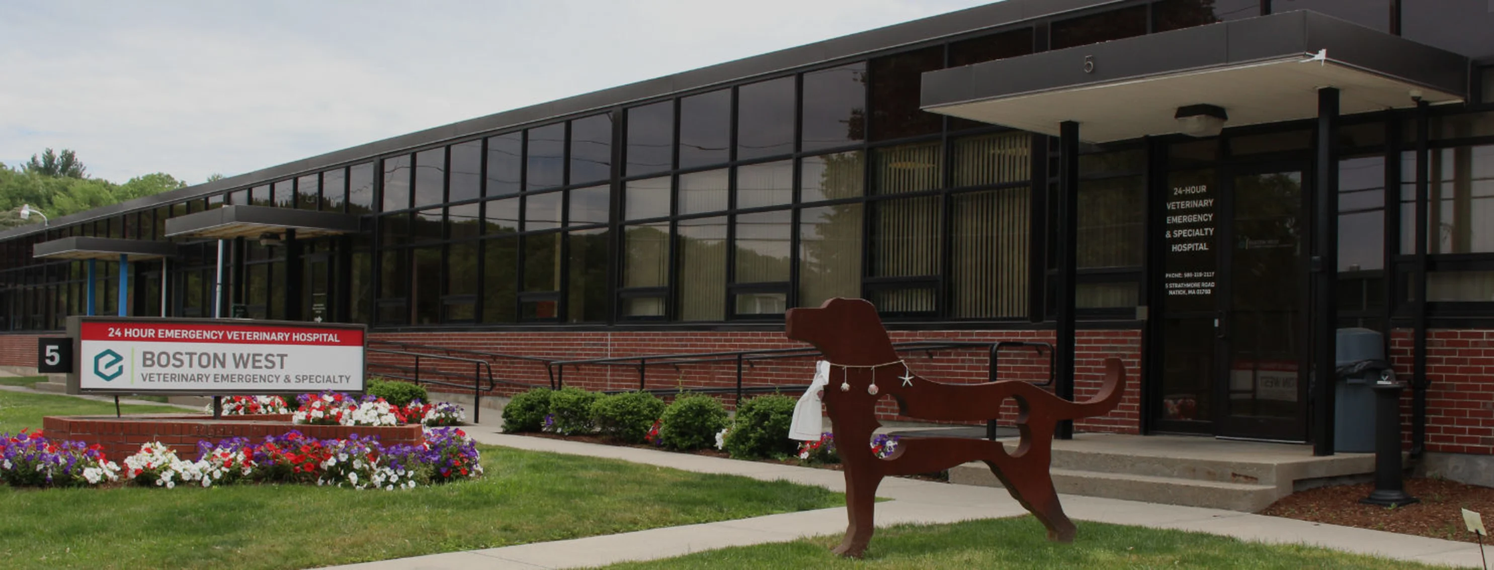 Boston West Veterinary Emergency Services hospital exterior sign and wooden rocking dog