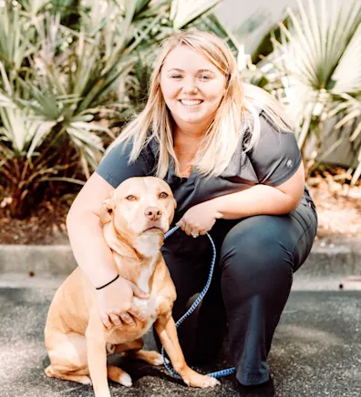 A staff member posing with a dog A staff member posing with a dog