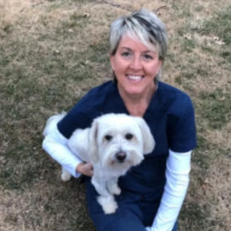A technician posing with a dog A technician posing with a dog