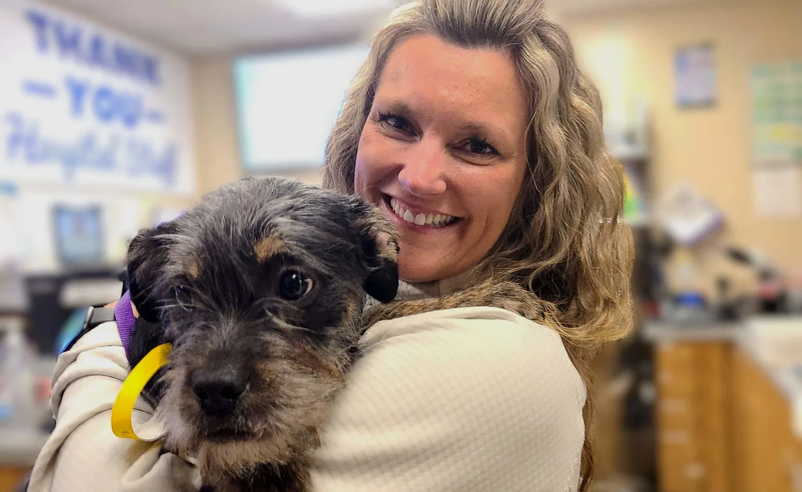 Dr. Brink holding a black and brown dog. Dr. Brink holding a black and brown dog.