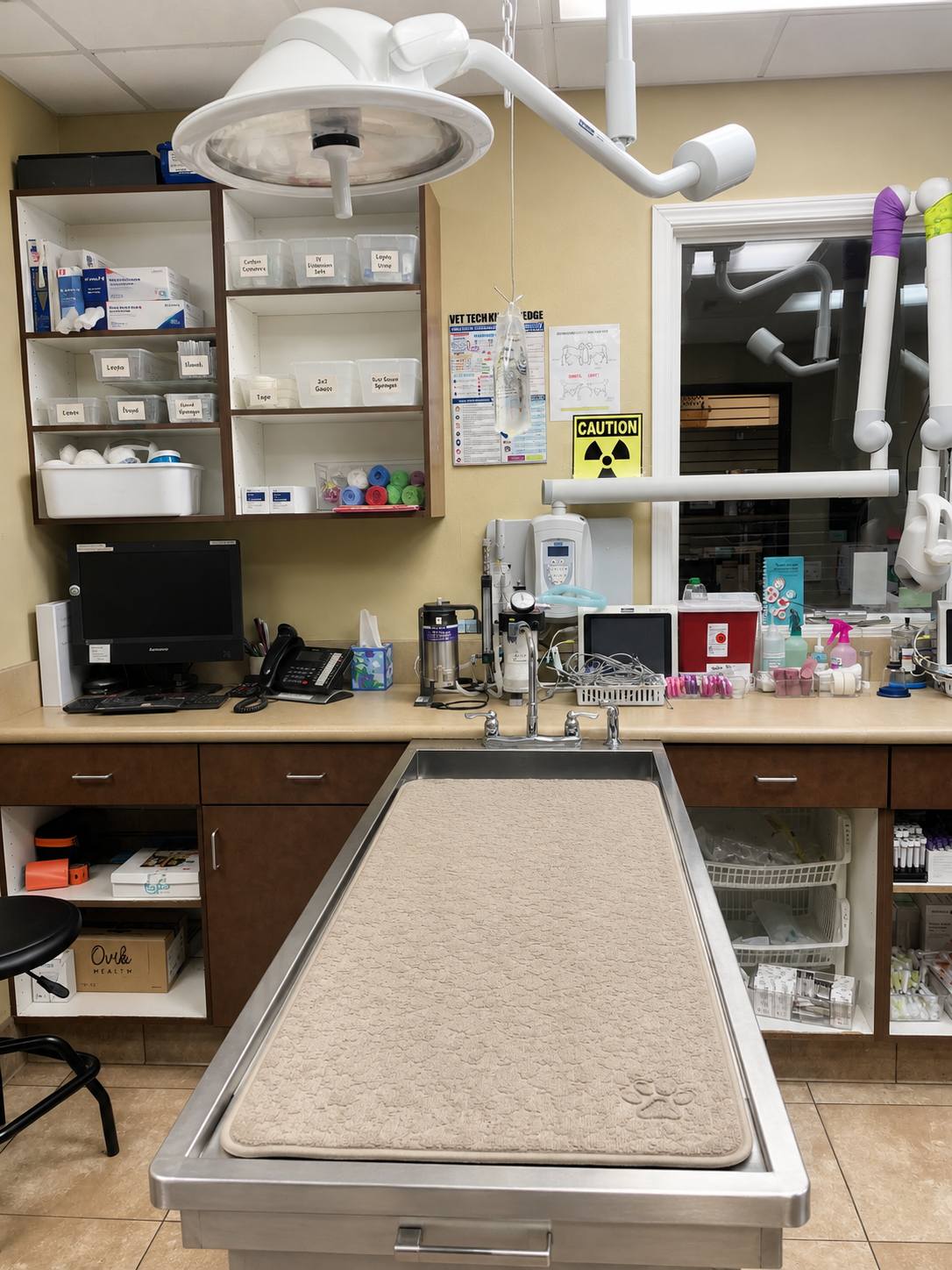 Exam table with shelves of medicinal supplies behind it.