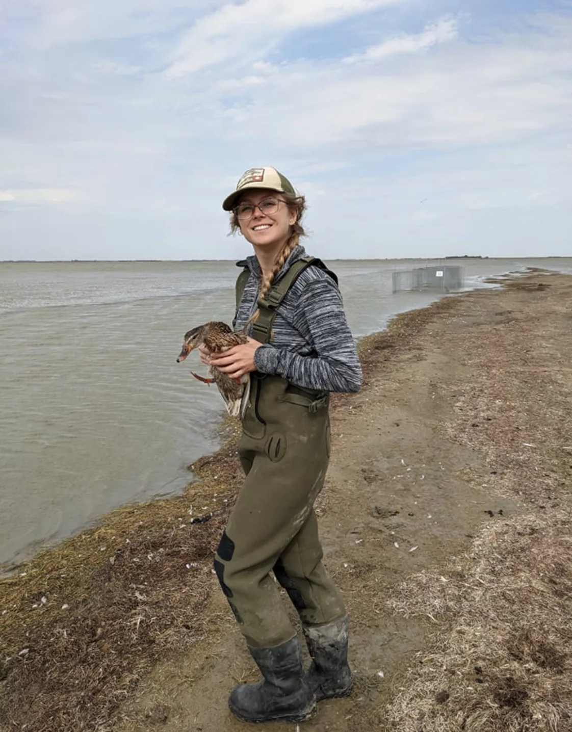Brenna near a lake while holding a duck. Brenna near a lake while holding a duck.