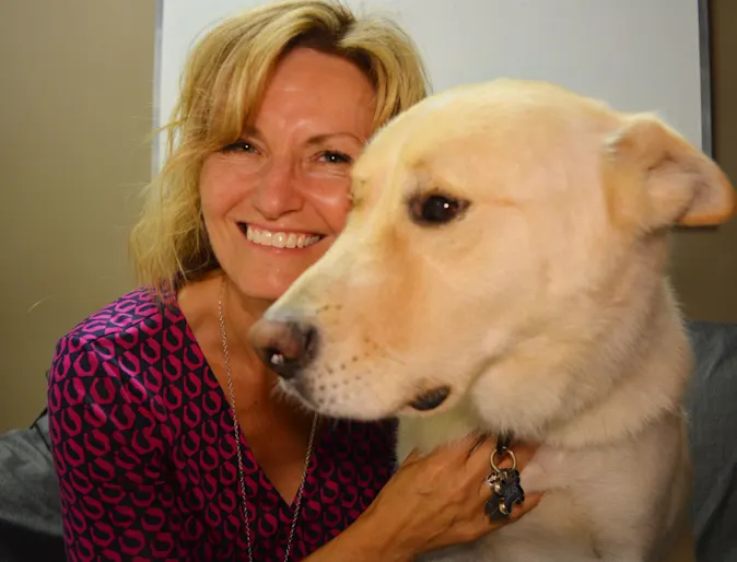 Woman smiling while holding a golden retriever. Woman smiling while holding a golden retriever.
