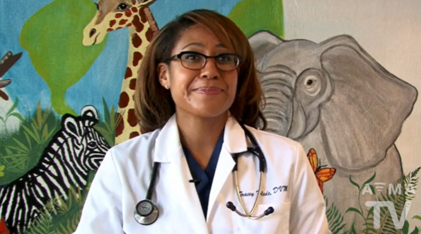 Woman with labcoat speaking to camera