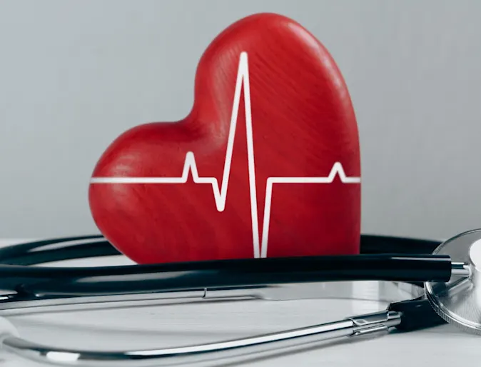 red heart with lifeline printer on it and a stethoscope next to it. red heart with lifeline printer on it and a stethoscope next to it.