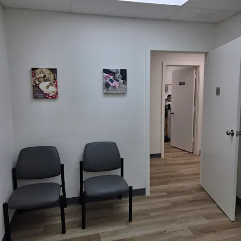 A room with two chairs and two paintings on the wall A room with two chairs and two paintings on the wall