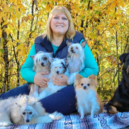 Laura Pabst, posing with five small dogs