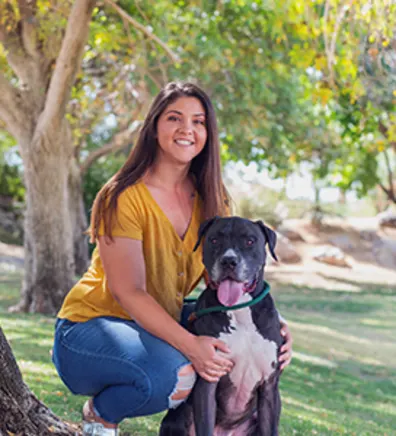 Danielle Martino kneeling with a black and white dog Danielle Martino kneeling with a black and white dog