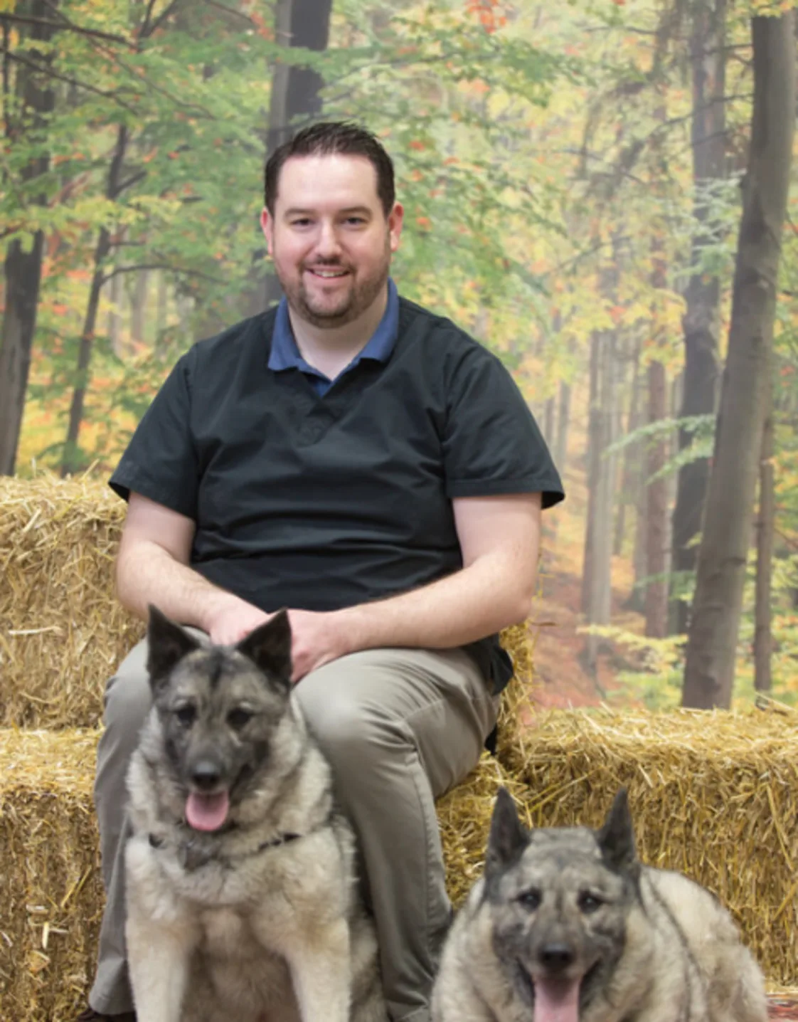 Dr. Jeff Brisebois sitting on hay with two dogs Dr. Jeff Brisebois sitting on hay with two dogs