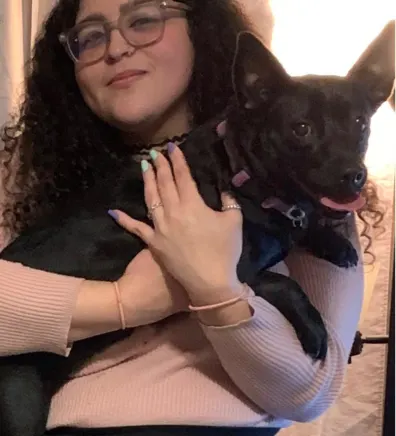 Samantha, groomer at Pompano Pet Lodge, holding a dog