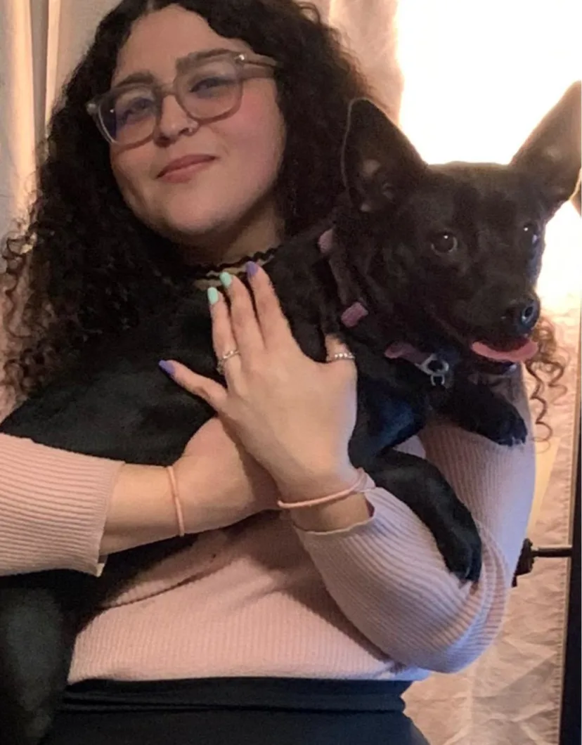Samantha, groomer at Pompano Pet Lodge, holding a dog