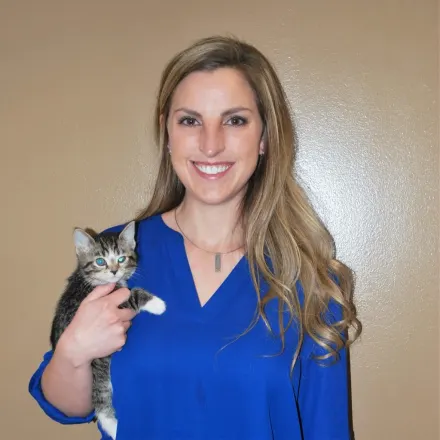 Dr. Jennifer Mutchler smiling at the camera while holding a kitten