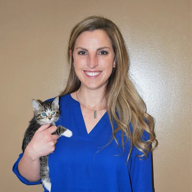 Dr. Jennifer Mutchler smiling at the camera while holding a kitten Dr. Jennifer Mutchler smiling at the camera while holding a kitten
