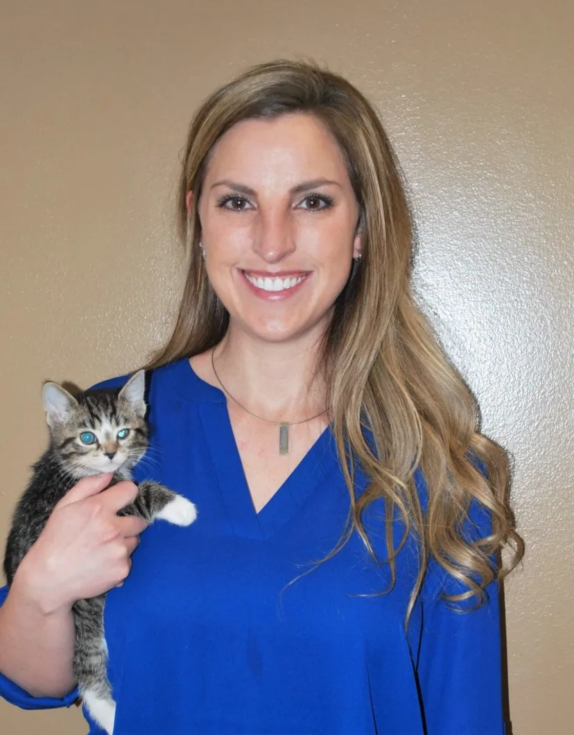 Dr. Jennifer Mutchler smiling at the camera while holding a kitten