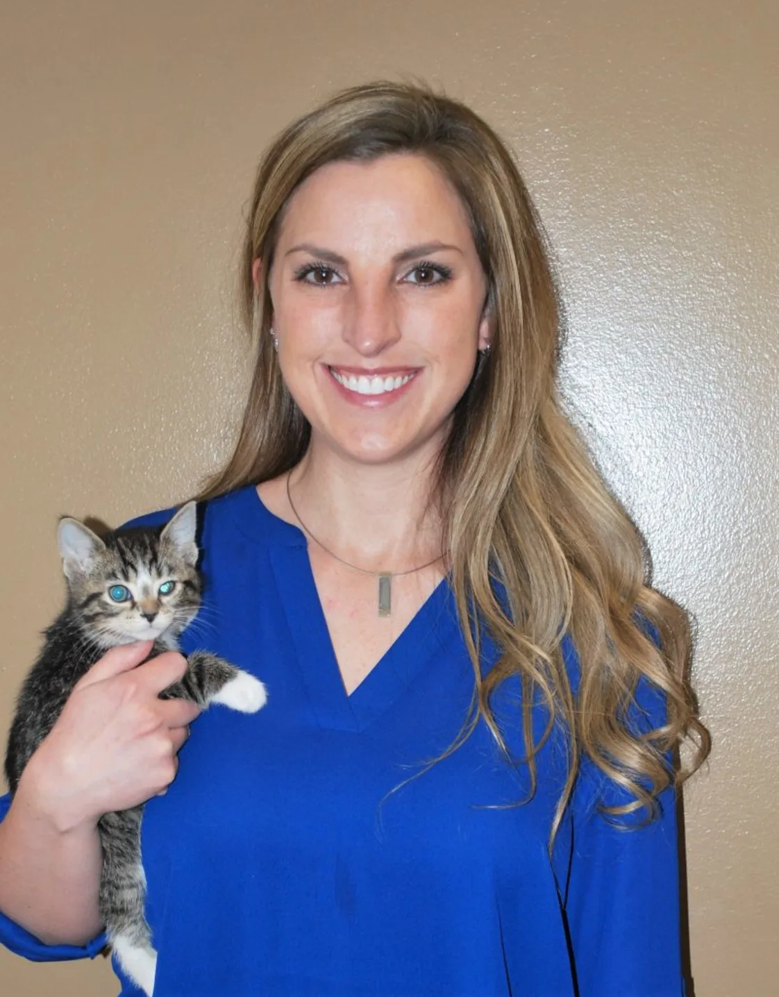 Dr. Jennifer Mutchler smiling at the camera while holding a kitten Dr. Jennifer Mutchler smiling at the camera while holding a kitten