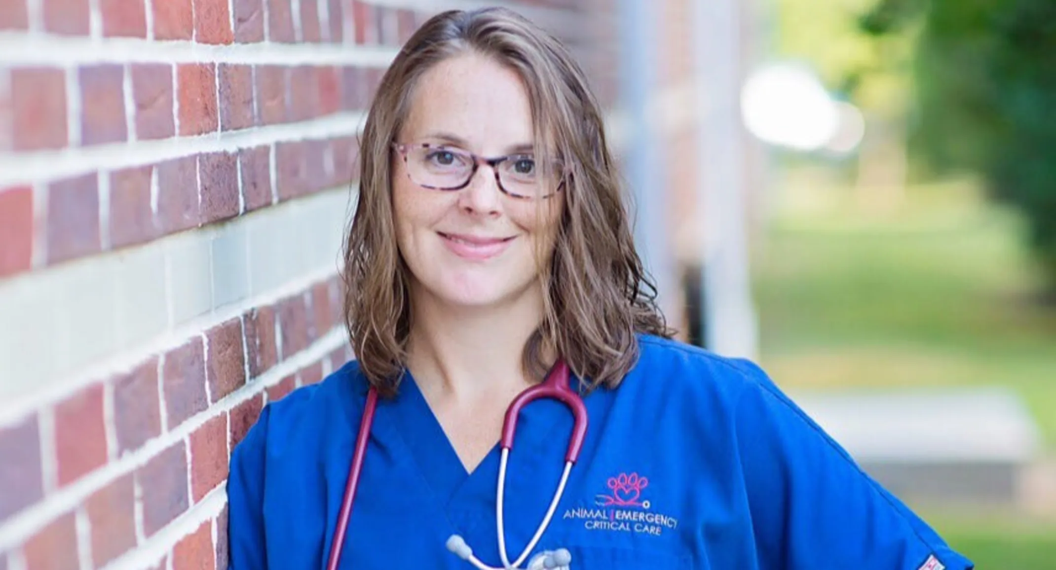 Staff member Julie by brick wall Staff member Julie by brick wall