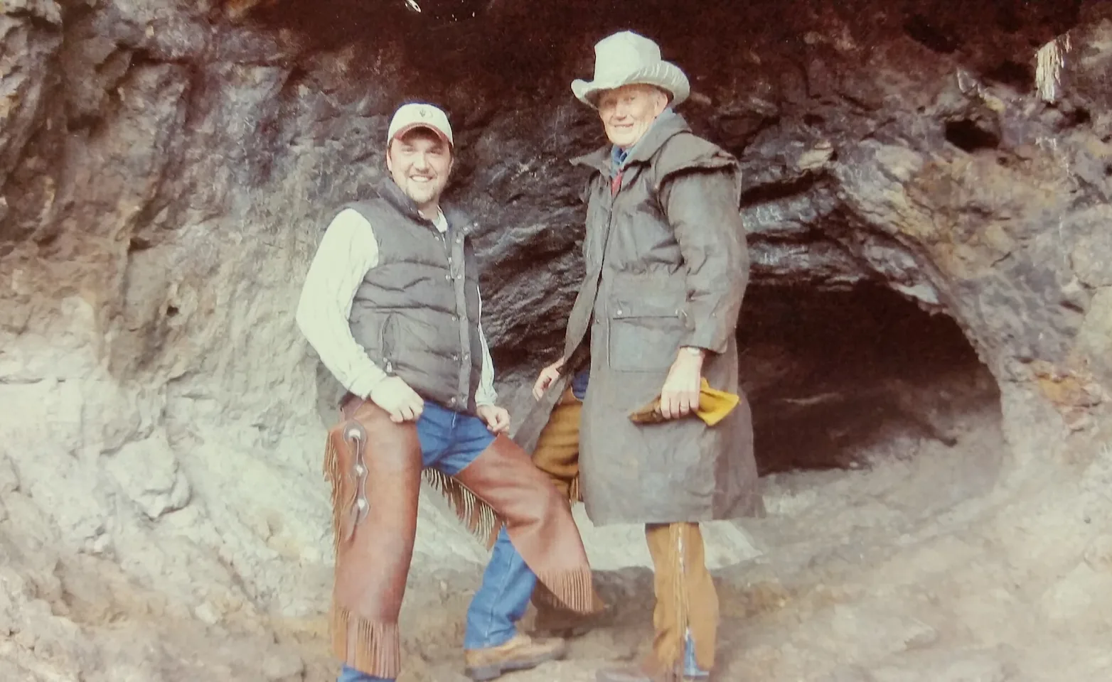 TWO MEN STANDING AT A CAVE