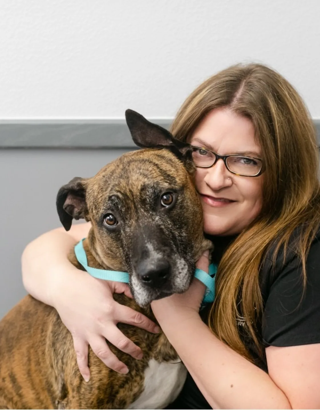 Sarah wearing a mask and holding a dog at All Pet Complex Veterinary Hospital Sarah wearing a mask and holding a dog at All Pet Complex Veterinary Hospital