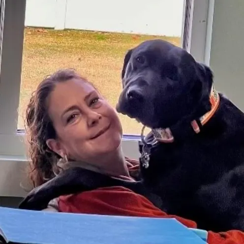 Staff member holding a black dog Staff member holding a black dog