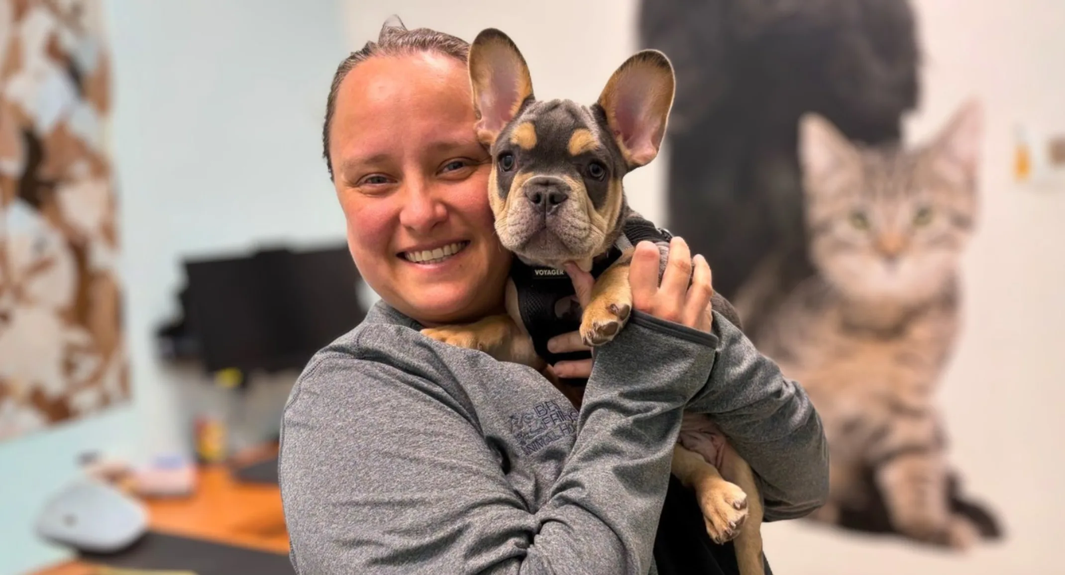 Alix smiling while holding a french bulldog. Alix smiling while holding a french bulldog.