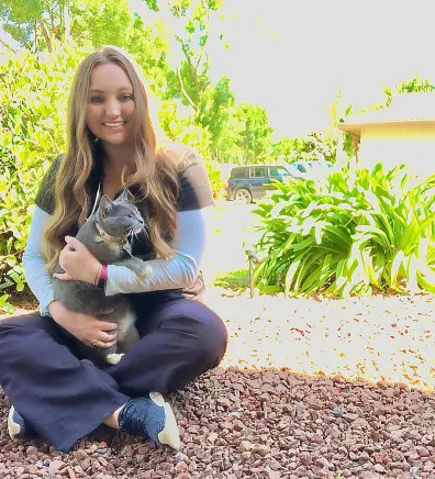 Briana's staff photo from Merced Animal Medical Center where she is sitting down with her cat on her lap.