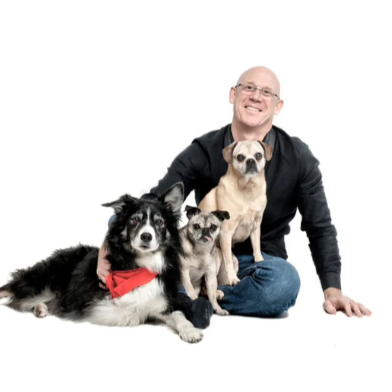 A portrait photo of Dr. Tyson Bull with his three dogs A portrait photo of Dr. Tyson Bull with his three dogs