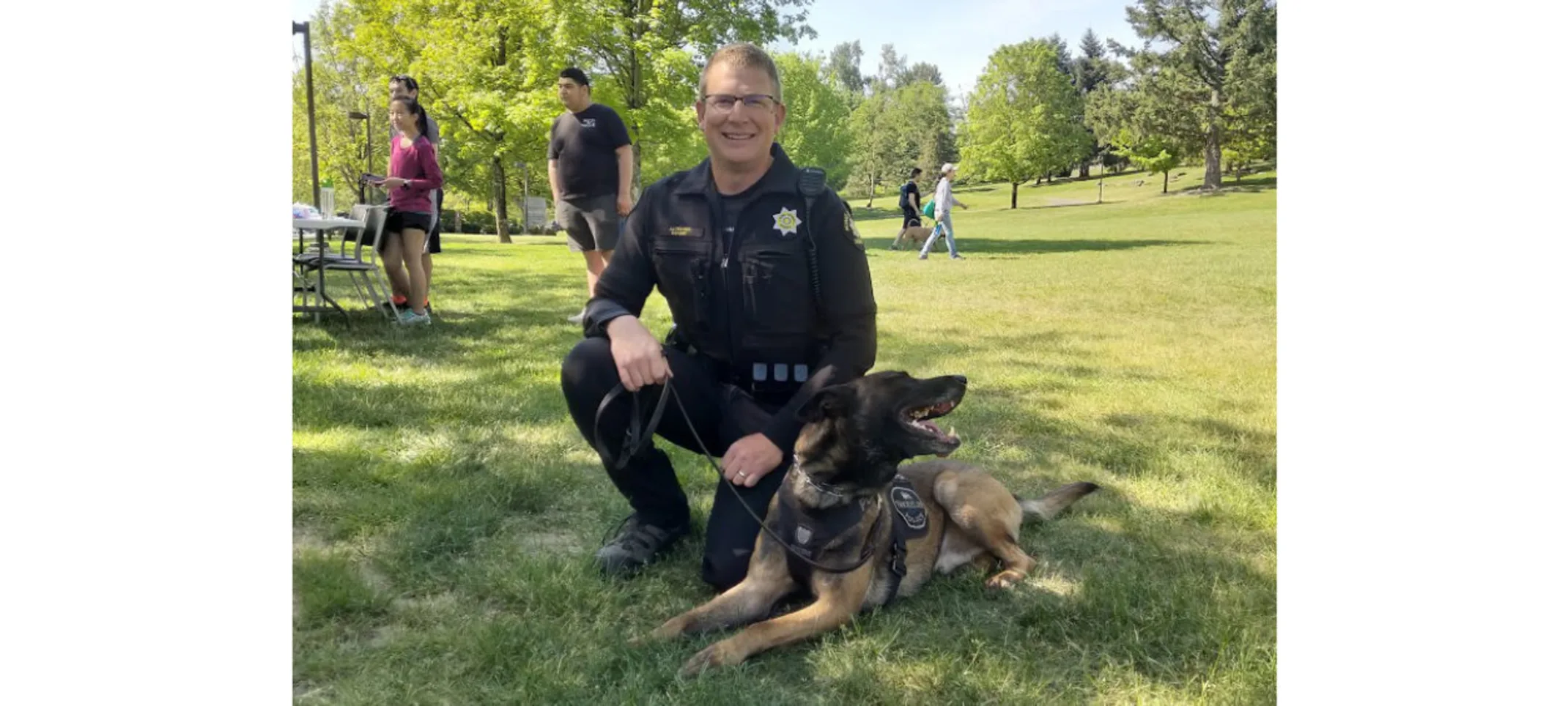Officer smiling with a German Shephard. Officer smiling with a German Shephard.