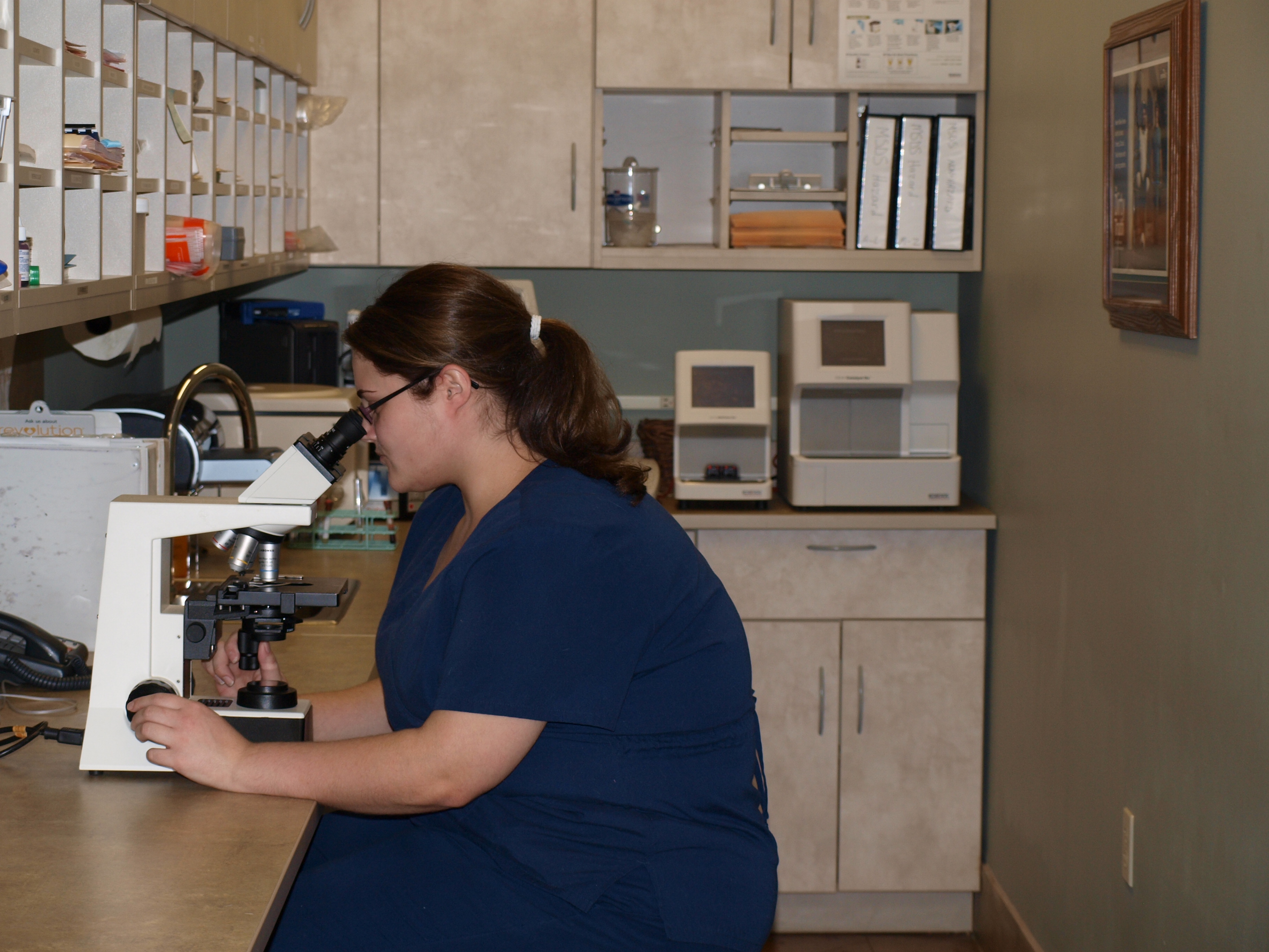Tech looking through microscope