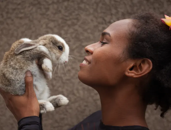 Woman holding rabbit up close