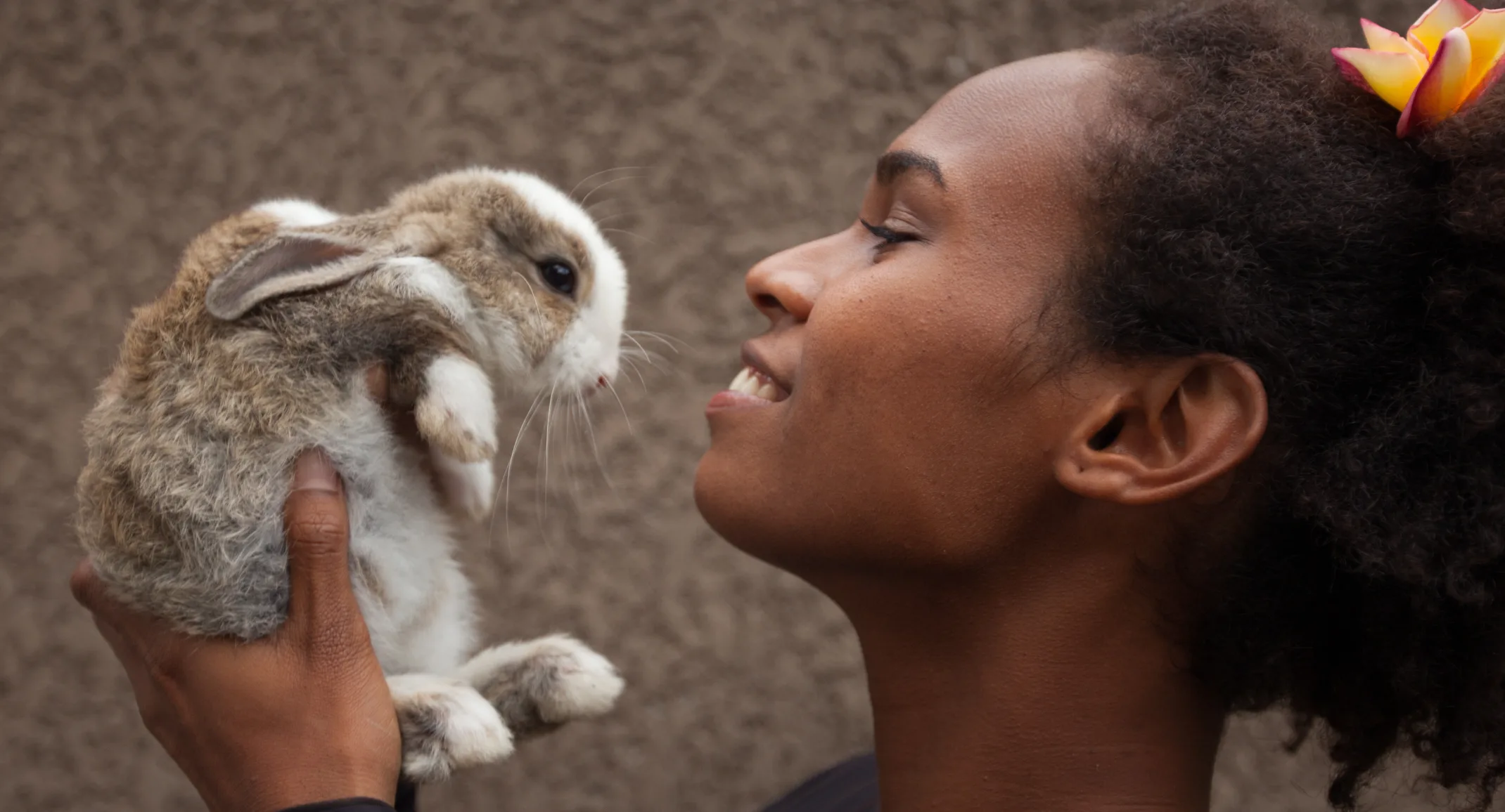 Woman holding rabbit up close