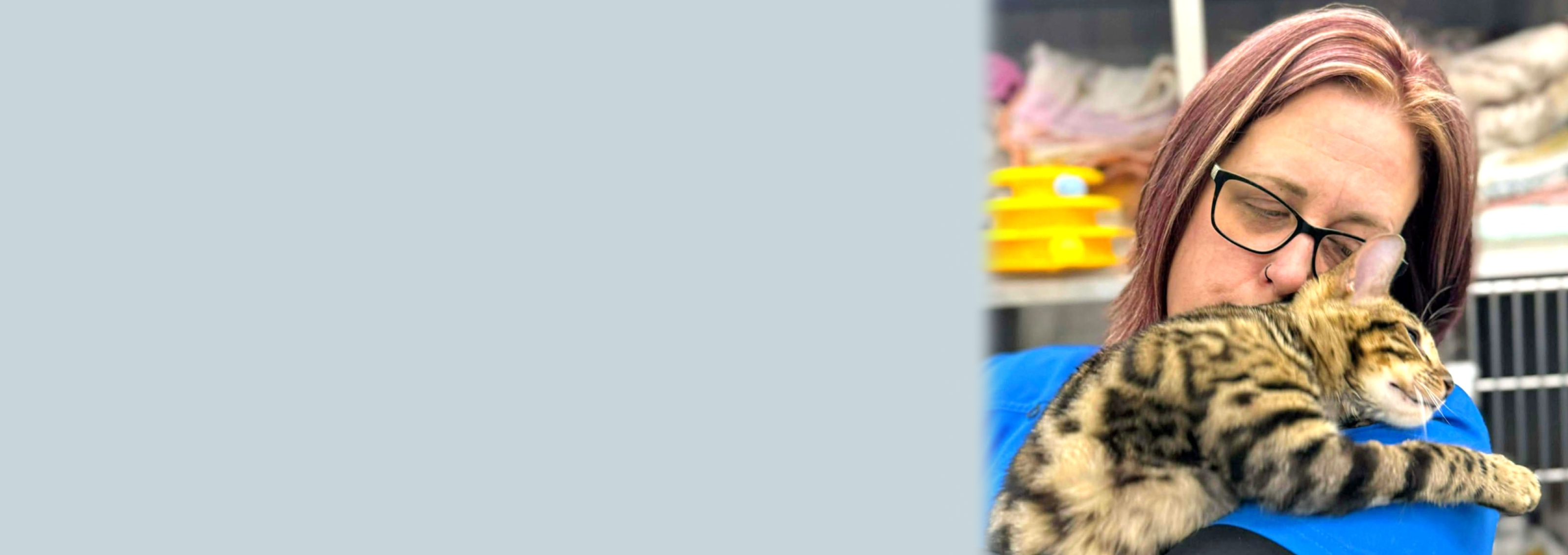 A vet holding a cat in her arms