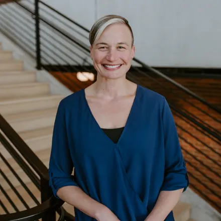 Dr. Christine Brennan smiling in front of stairs