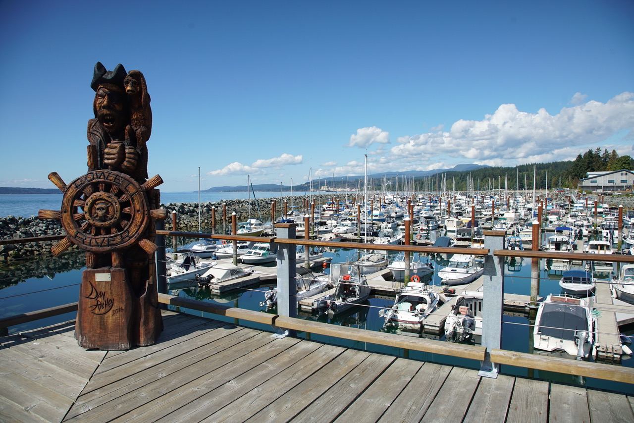 Wooden totem pool sitting on a dock on a boatyard.