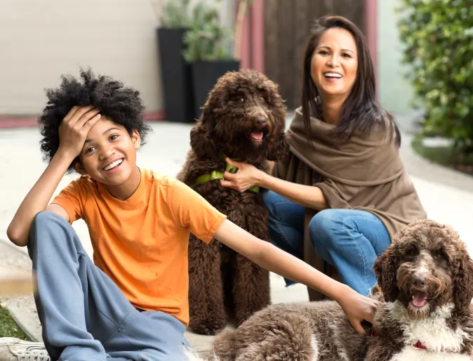 two people with dogs in front of house