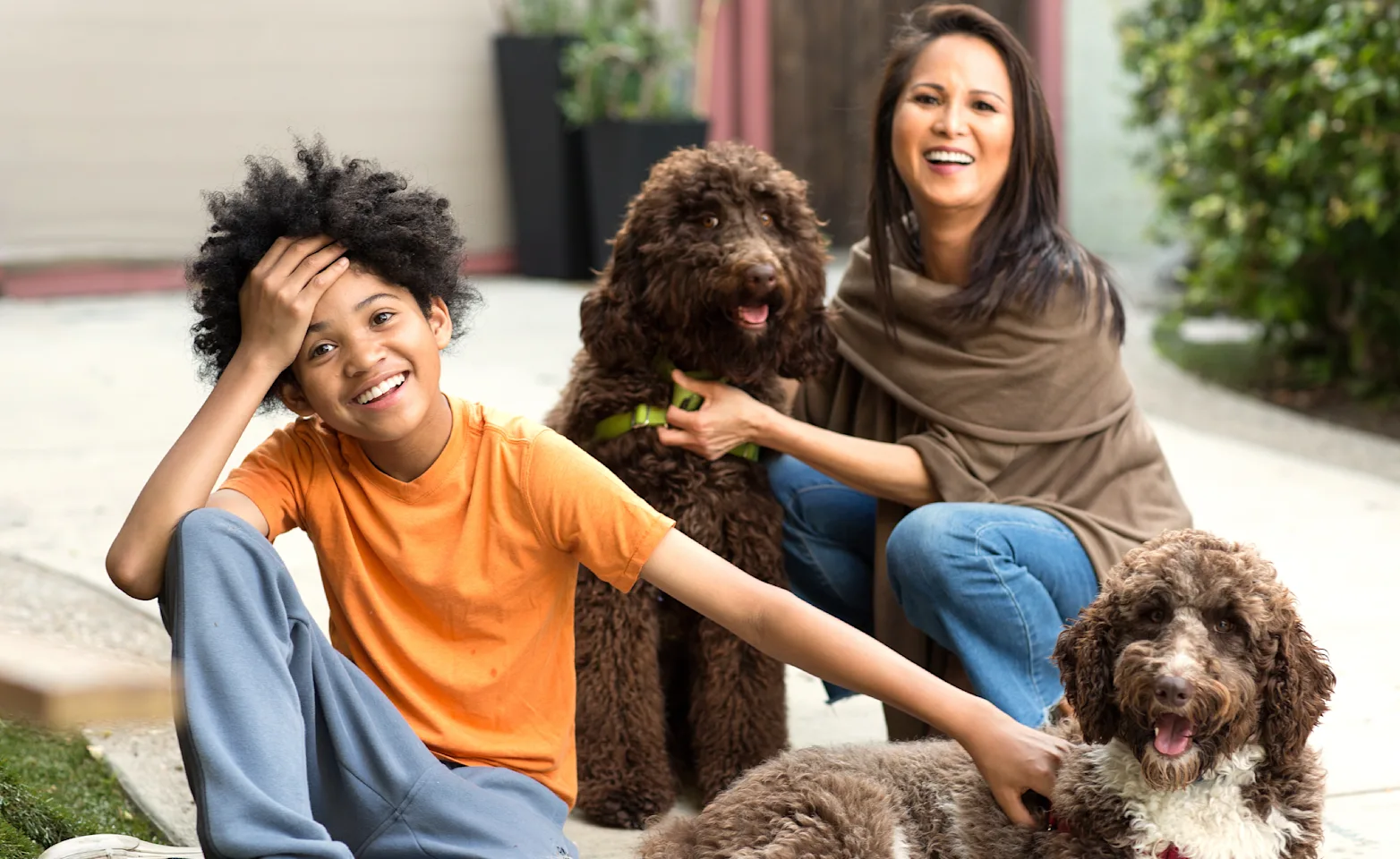 two people with dogs in front of house