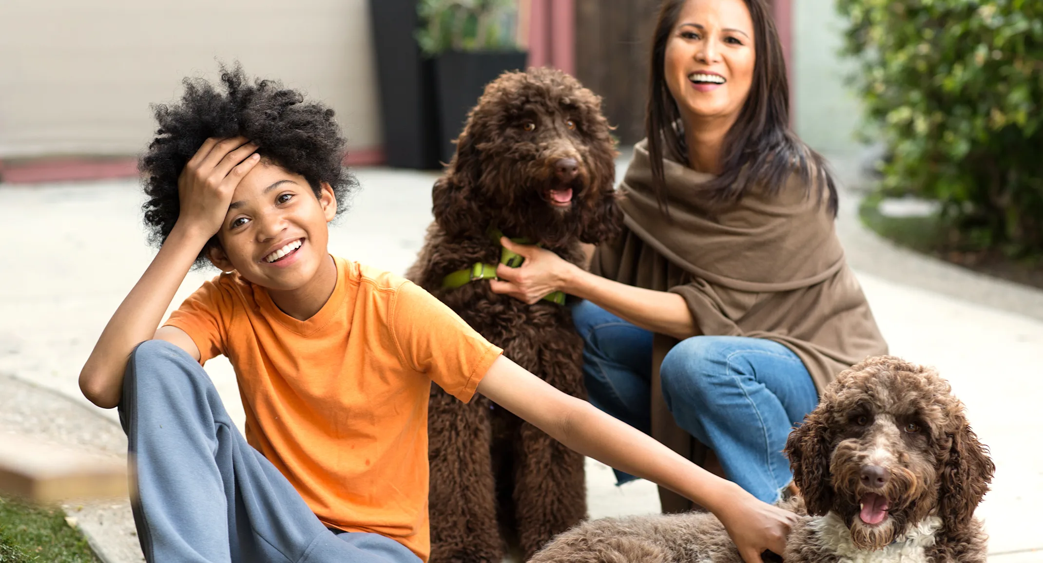 two people with dogs in front of house two people with dogs in front of house