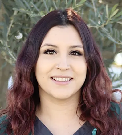 Woman with green scrubs smiling at the camera Woman with green scrubs smiling at the camera