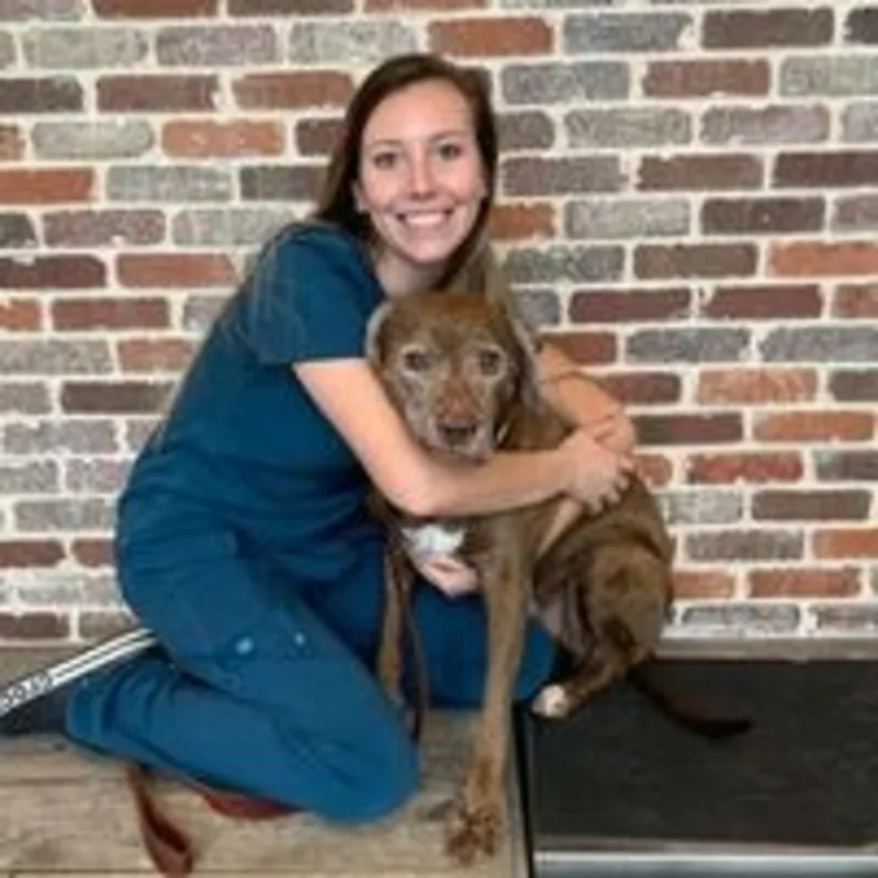 Tiffany Kaylor kneeling down next to a brown dog Tiffany Kaylor kneeling down next to a brown dog