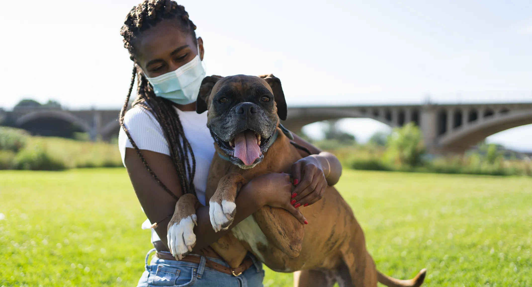 Girl wearing a mask and holding a dog