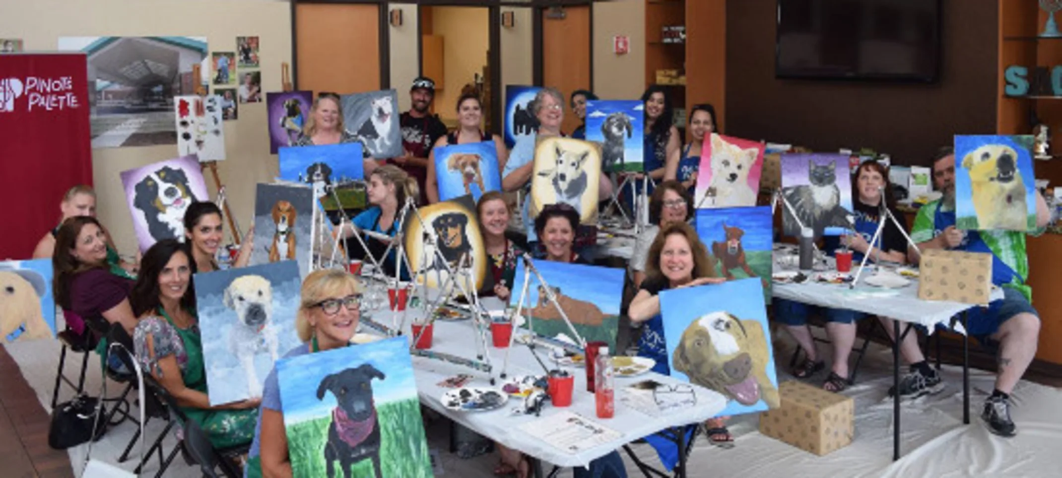 staff showing off paintings staff showing off paintings