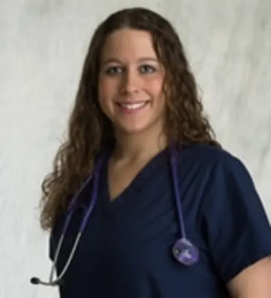 Jessica Spruill's staff photo from Strawbridge Animal Care where she is wearing a navy blue scrub and has a stethoscope hanging off her neck, shoulders.