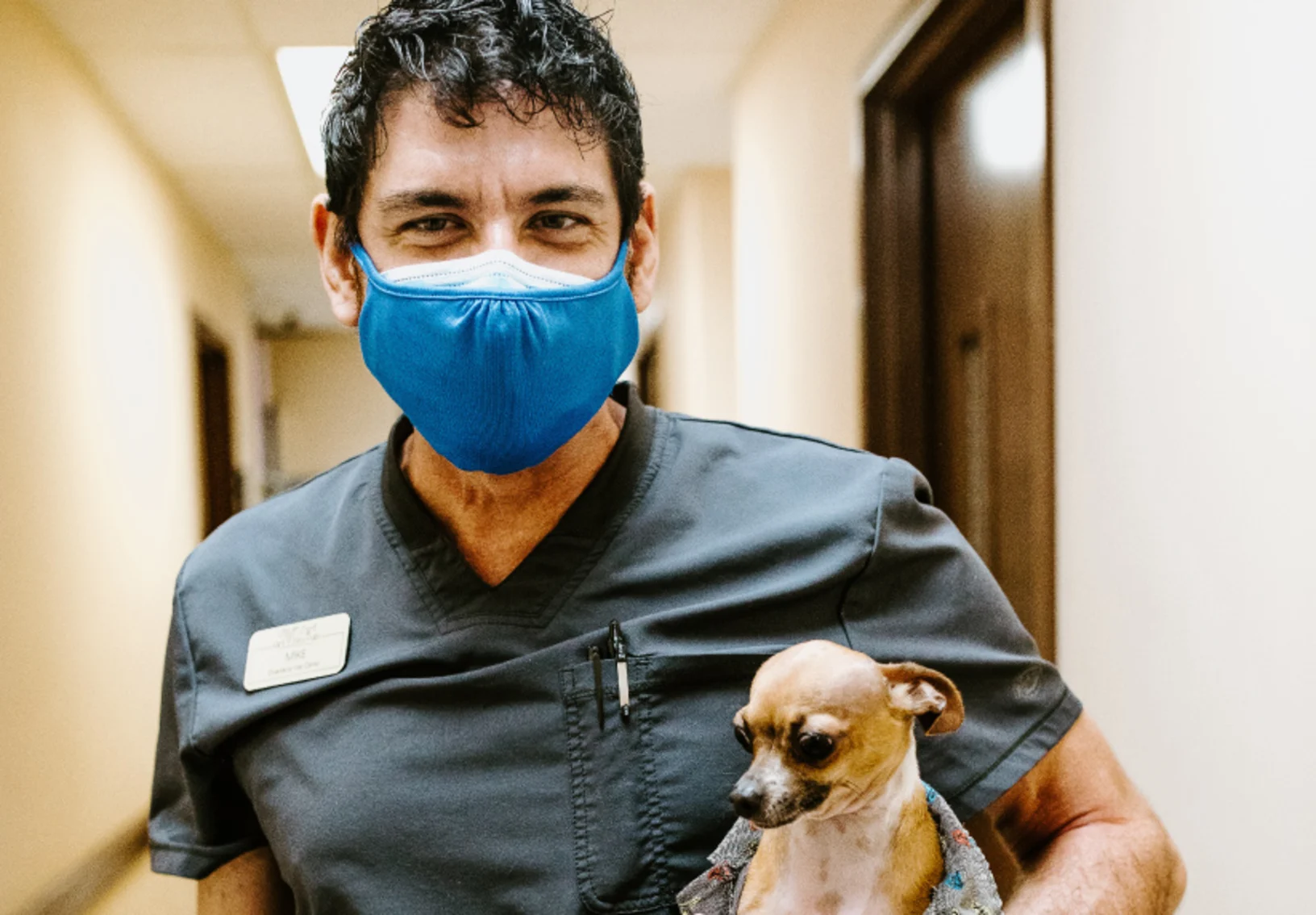 Staff Mike holding little dog at Overland Veterinary Clinic