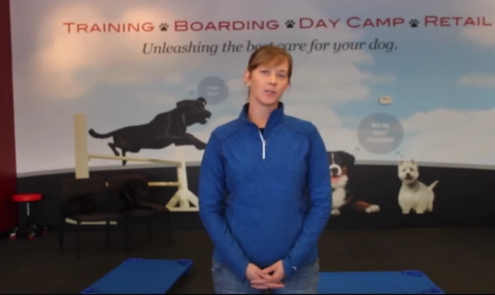 Blonde woman in blue shirt in a dog training facility.