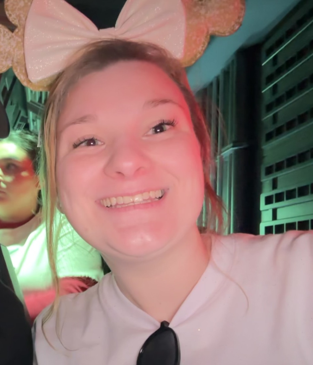 Kristen Triblle smiling with a white t-shirt and a headband with a bow