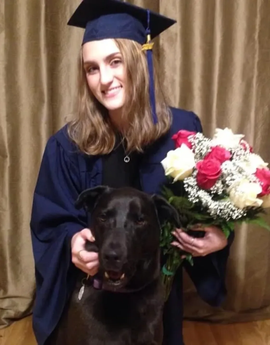Staff photo of Lianne in a cap and gown, holding flowers with a dog in front of her Staff photo of Lianne in a cap and gown, holding flowers with a dog in front of her
