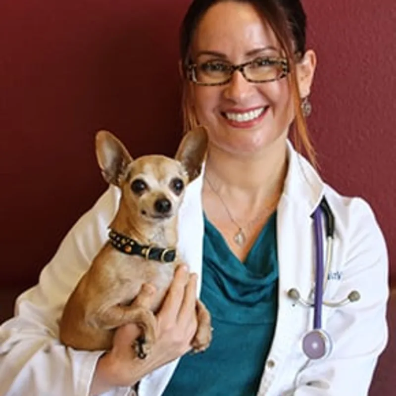 Dr. Malena Arvizu smiling while holding a dog Dr. Malena Arvizu smiling while holding a dog