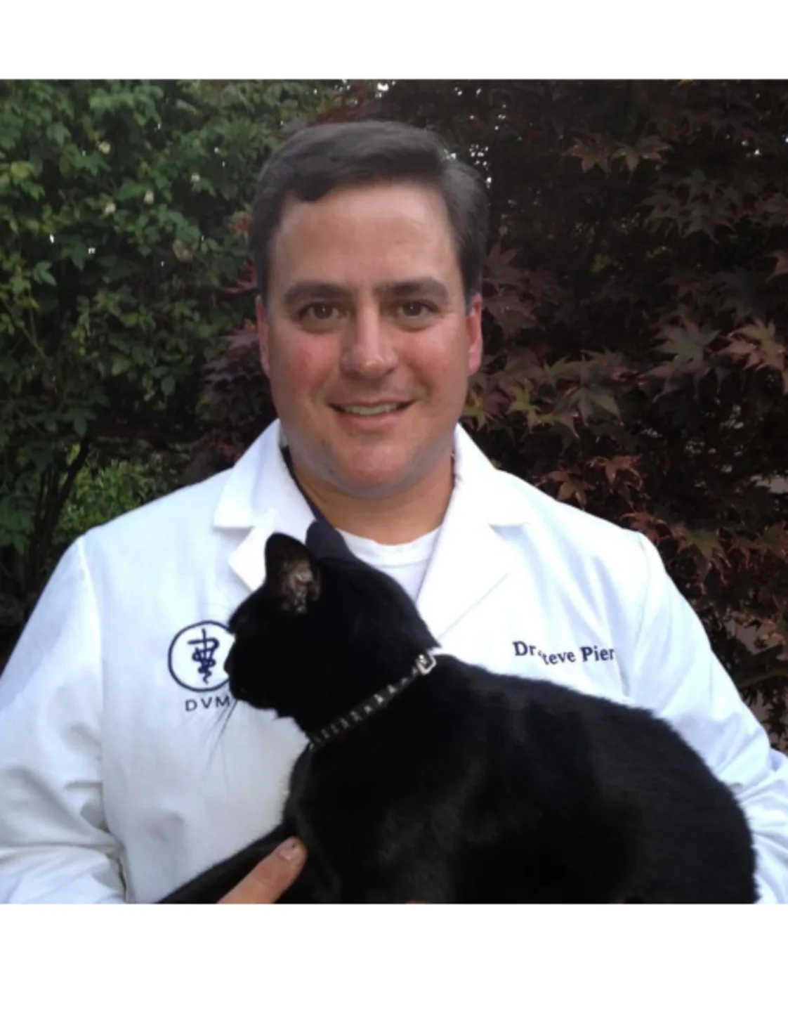 Dr. Steven Piert is holding onto a black cat. Dr. Steven Piert is holding onto a black cat.