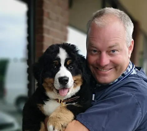 Dr. Kaufmann smiling with shepherd dog Dr. Kaufmann smiling with shepherd dog
